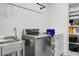 Functional laundry room with stainless steel washer, white dryer, utility sink, and storage shelves at 8703 Jenny Lind St, North Charleston, SC 29406