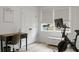 Bright office space with a desk, exercise bike, and natural light streaming in from a window at 8703 Jenny Lind St, North Charleston, SC 29406