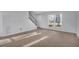 Living room with stairwell, carpeted flooring, and a large window that offers a view to the exterior at 926 Lansing Dr # 926-G, Mount Pleasant, SC 29464