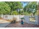 Charming backyard entrance featuring a white fence with a decorative gate and a brick patio at 968 Cummings Cir, Mount Pleasant, SC 29464