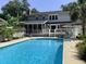 A picturesque backyard with in-ground pool, patio, lush greenery, and the home's screened-in porch at 968 Cummings Cir, Mount Pleasant, SC 29464