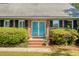Close-up of brick entryway featuring charming blue double doors with black shutters and manicured shrubs at 968 Cummings Cir, Mount Pleasant, SC 29464