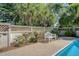 White park bench sits adjacent to a stunning pool and rose garden at 968 Cummings Cir, Mount Pleasant, SC 29464