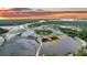 Breathtaking aerial view of a waterfront property at sunset, showcasing the unique coastal landscape at 000 Remington Trl, Johns Island, SC 29455