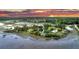 Picturesque aerial shot of waterfront homes, serene landscaping, and stunning sunset backdrop at 000 Remington Trl, Johns Island, SC 29455