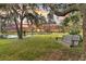 Serene backyard view with a swing beneath a tree, overlooking a tranquil pond at sunset at 000 Remington Trl, Johns Island, SC 29455