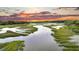 Panoramic marsh view with lush vegetation, calm waters, and a colorful sunset sky at 000 Remington Trl, Johns Island, SC 29455