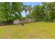 Large backyard with lush green grass, mature trees, and a partial privacy fence at 1024 Willowood Ave, Goose Creek, SC 29445