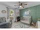 Cozy Bedroom with green accent wall, crib, comfortable chair, and natural light at 1024 Willowood Ave, Goose Creek, SC 29445