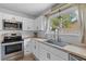 Bright kitchen with stainless steel appliances, light countertops, and a large sink under a window at 1024 Willowood Ave, Goose Creek, SC 29445