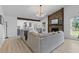 Spacious living room with stone fireplace, wood beam, and cozy sectional sofa with modern lighting at 1024 Willowood Ave, Goose Creek, SC 29445