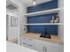 Stylish wet bar with butcher block countertop, white cabinetry, and open shelving against a dark blue wall at 1024 Willowood Ave, Goose Creek, SC 29445