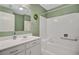 Bright bathroom with white tiles, a bathtub-shower combination, and ample vanity space at 106 Newington Rd, Summerville, SC 29485