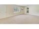 Spacious bedroom with neutral carpet, a window overlooking the yard, and a wall-mounted television at 106 Newington Rd, Summerville, SC 29485