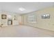 Open living room with neutral carpet, a large window, a wall mounted television, and access to the kitchen at 106 Newington Rd, Summerville, SC 29485