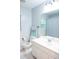 Bright bathroom with shower and white cabinets, accented with blue towels and rugs at 109 Holly St, Summerville, SC 29485