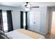 Bright bedroom featuring carpeting, ceiling fan, double door closet, and large windows with dark drapes at 109 Holly St, Summerville, SC 29485