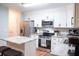 Modern kitchen with white cabinets, stainless steel appliances, and island with marble countertops at 109 Holly St, Summerville, SC 29485