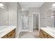 Modern bathroom featuring double sinks, a glass-enclosed shower, and neutral tiling at 1171 Hammrick Ln, Johns Island, SC 29455