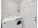 A functional laundry room with a washer, dryer, wire shelving, and a utility door at 1171 Hammrick Ln, Johns Island, SC 29455