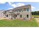 Back exterior view of a two-story home with a screened-in porch and spacious green backyard at 120 Shingle Oak Dr, Moncks Corner, SC 29461