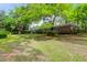 Lush backyard featuring mature trees and a well-maintained single-story brick house at 1251 Charlestowne Dr, Charleston, SC 29407