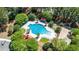 Aerial view showcasing a sparkling community pool, clubhouse, lounge chairs, and playground, surrounded by verdant trees at 1315 Palm Cove Dr, Charleston, SC 29492