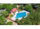 Aerial view featuring a community pool, lounging area, clubhouse, and playground surrounded by mature trees at 1315 Palm Cove Dr, Charleston, SC 29492