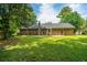Backyard features a well maintained lawn and a brick home exterior with a chimney and patio area at 136 Harrow Pl, Goose Creek, SC 29445