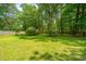 Backyard with a lush green lawn and mature trees creating a serene, park-like setting at 136 Harrow Pl, Goose Creek, SC 29445