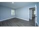 Cozy bedroom features wood-look flooring, neutral walls, trim, and a bright window for a serene and restful space at 136 Harrow Pl, Goose Creek, SC 29445