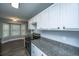Bright kitchen boasts stainless steel appliances, gray countertops, white cabinets and wood-look flooring at 136 Harrow Pl, Goose Creek, SC 29445
