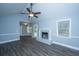 Cozy living room with vaulted ceilings, hardwood floors, fan, fireplace, and a sliding glass door at 136 Harrow Pl, Goose Creek, SC 29445