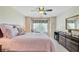 Sunlit bedroom featuring a ceiling fan and bedside dresser plus a cozy chair by a large window at 1503 Pondside Ct, Summerville, SC 29485