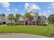 Charming brick home featuring a manicured lawn, decorative landscaping, and picturesque neighborhood setting at 1503 Pondside Ct, Summerville, SC 29485