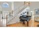 Grand foyer with staircase, piano, and gleaming hardwood floors at 1503 Pondside Ct, Summerville, SC 29485