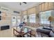 Cozy sunroom features comfortable seating, a ceiling fan, and access to the patio with pool views at 1503 Pondside Ct, Summerville, SC 29485