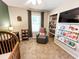 Bedroom features a glider, crib, built-in shelves, carpet flooring, and a window providing natural light at 1534 Kentwood Cir, Charleston, SC 29412