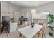 Bright dining area featuring white table, woven chairs, chandelier, and natural light from a large window at 1610 Fishbone Dr, Johns Island, SC 29455