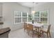Bright dining area featuring white table, woven chairs, chandelier, and natural light from large windows at 1610 Fishbone Dr, Johns Island, SC 29455