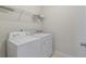This functional laundry area includes a washer, dryer, and overhead shelving for storage at 1610 Fishbone Dr, Johns Island, SC 29455
