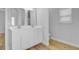 Bathroom featuring dual sinks, white cabinetry, large mirrors, and wood-look flooring at 168 Cotillion Cres, Summerville, SC 29483