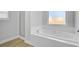 A bright bathroom features a drop-in soaking tub, a window, and a separate walk-in shower at 168 Cotillion Cres, Summerville, SC 29483