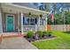 Charming porch with a teal door, rocking chairs, and lush landscaping at 168 Cotillion Cres, Summerville, SC 29483
