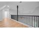Bright hallway with wood floors and modern black railing overlooking the floor below at 168 Cotillion Cres, Summerville, SC 29483
