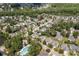 Aerial view showcasing a neighborhood with mature trees, a community pool, and a tranquil pond at 1708 Waterbrook Dr, Charleston, SC 29414