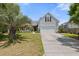 Inviting home featuring a manicured front lawn, mature palm trees, and a two-car garage at 1708 Waterbrook Dr, Charleston, SC 29414