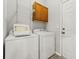 Functional laundry room includes a washer, dryer, overhead cabinet, and wire shelving for ample storage at 1708 Waterbrook Dr, Charleston, SC 29414