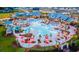 Aerial view of a resort-style pool area with palm trees, umbrellas, lounge chairs, and a waterslide at 172 Helena Park Dr, Summerville, SC 29486