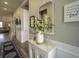 Neutral hallway with wood-look floors, beautiful decor, and a stylish hall table beneath a decorative mirror and framed art at 172 Helena Park Dr, Summerville, SC 29486
